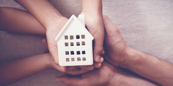 Adult And Child Hands Holding White House, Family Home And Homel