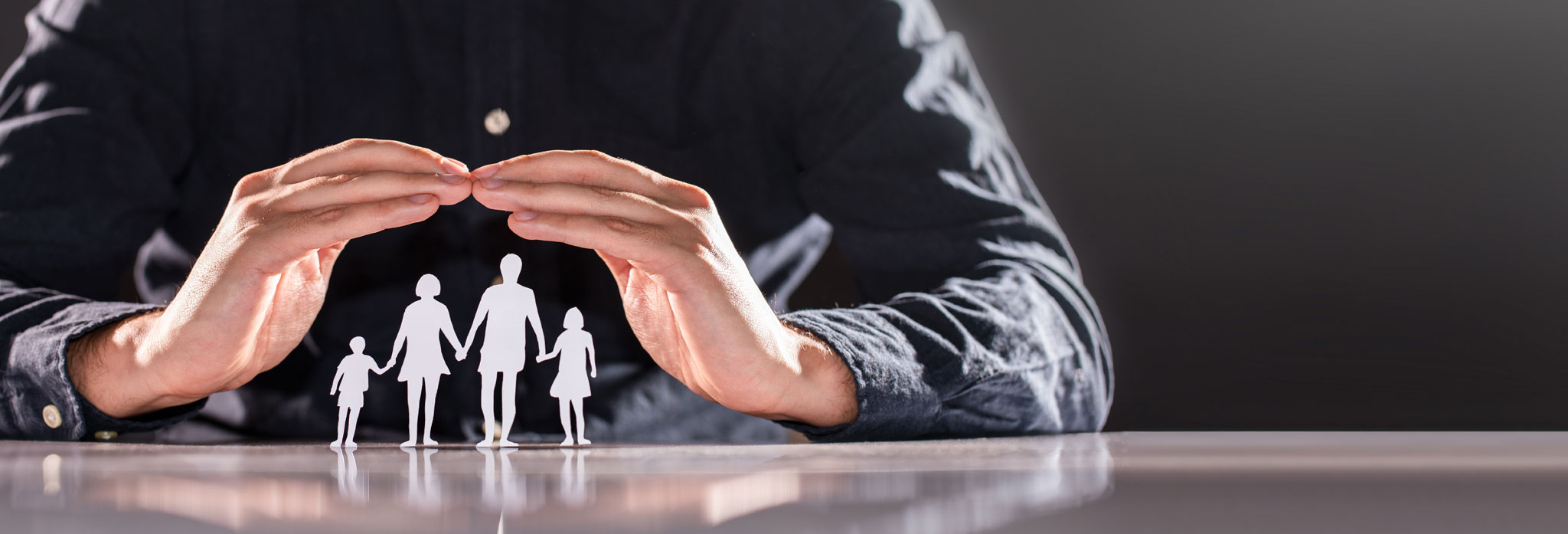 Family Care Concept. Hands With Paper Silhouette On Table.