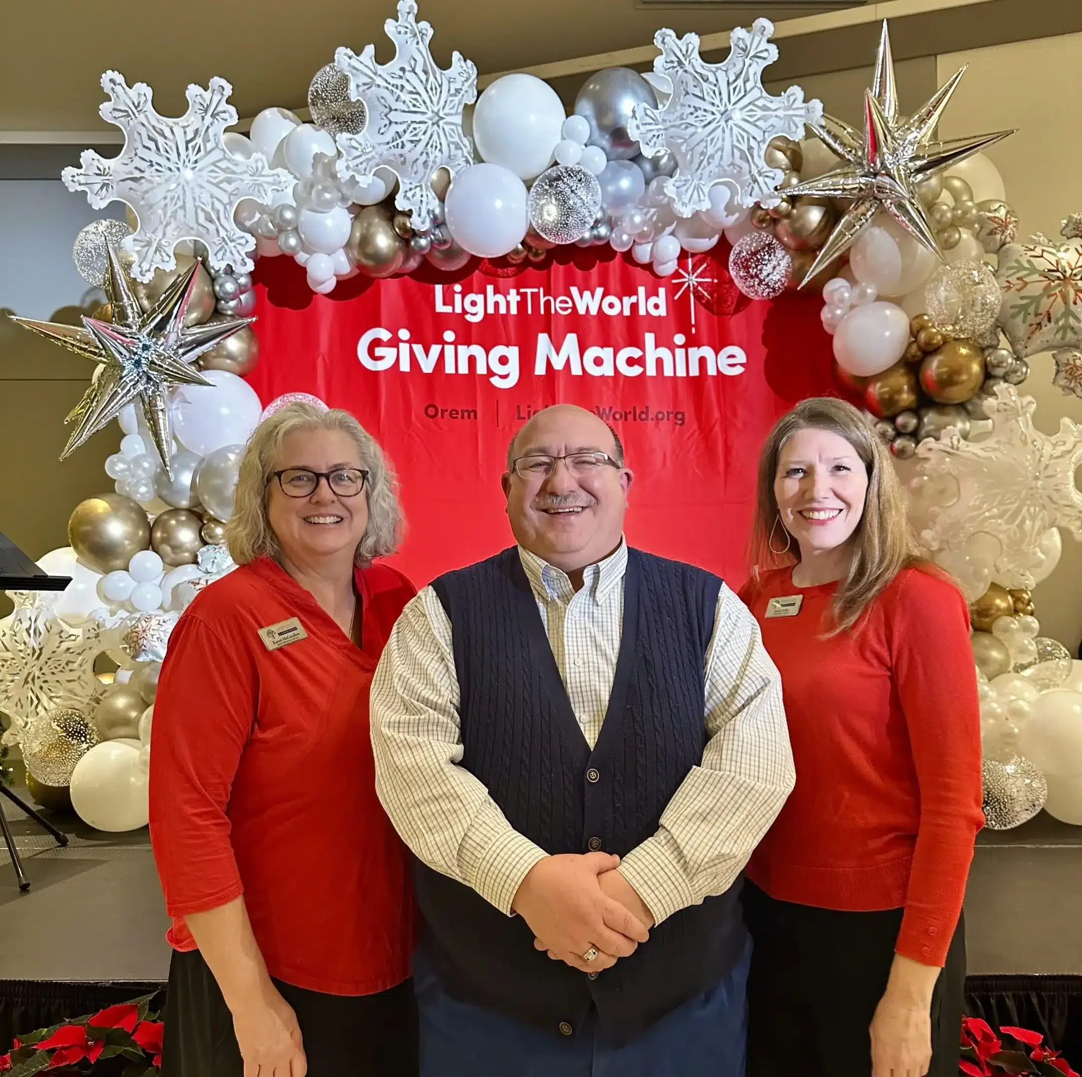 Red Giving Machine sign with 3 people in image